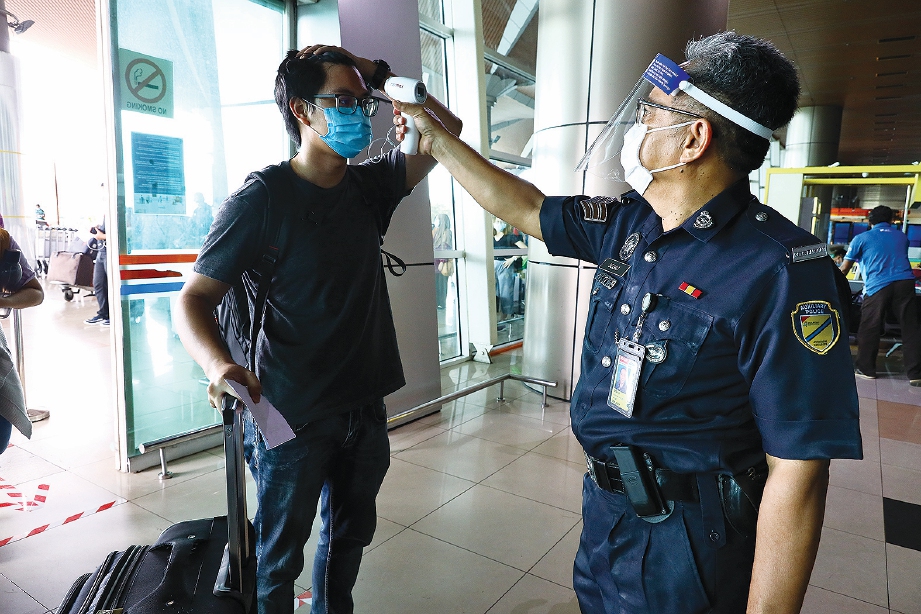 SUHU badan penuntut diperiksa pegawai bertugas ketika tiba di lapangan terbang.
