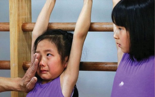 JURULATIH menenangkan kanak-kanak perempuan yang keletihan ketika kelas gimnastik.