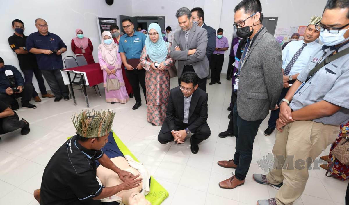 DR Nik Hisamuddin (tengah, duduk) melihat demonstrasi  rawatan asas perubatan kecemasan oleh Orang Asli selepas merasmikan Majlis Perasmian Penutupan Program Khidmat Masyarakat Bersama Orang Asli Pos Balar di Hospital USM. FOTO Nik Abdullah Nik Omar