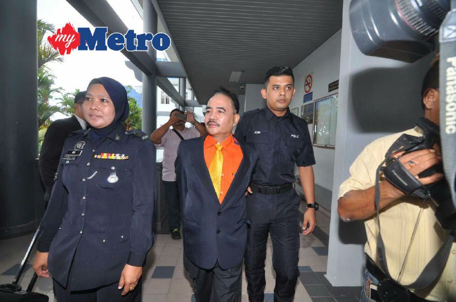 NOOR Jan diiringi polis keluar dari mahkamah selepas mengaku tidak bersalah atas tuduhan menyamar sebagai Sultan Melaka. FOTO Hatim Ab Manan