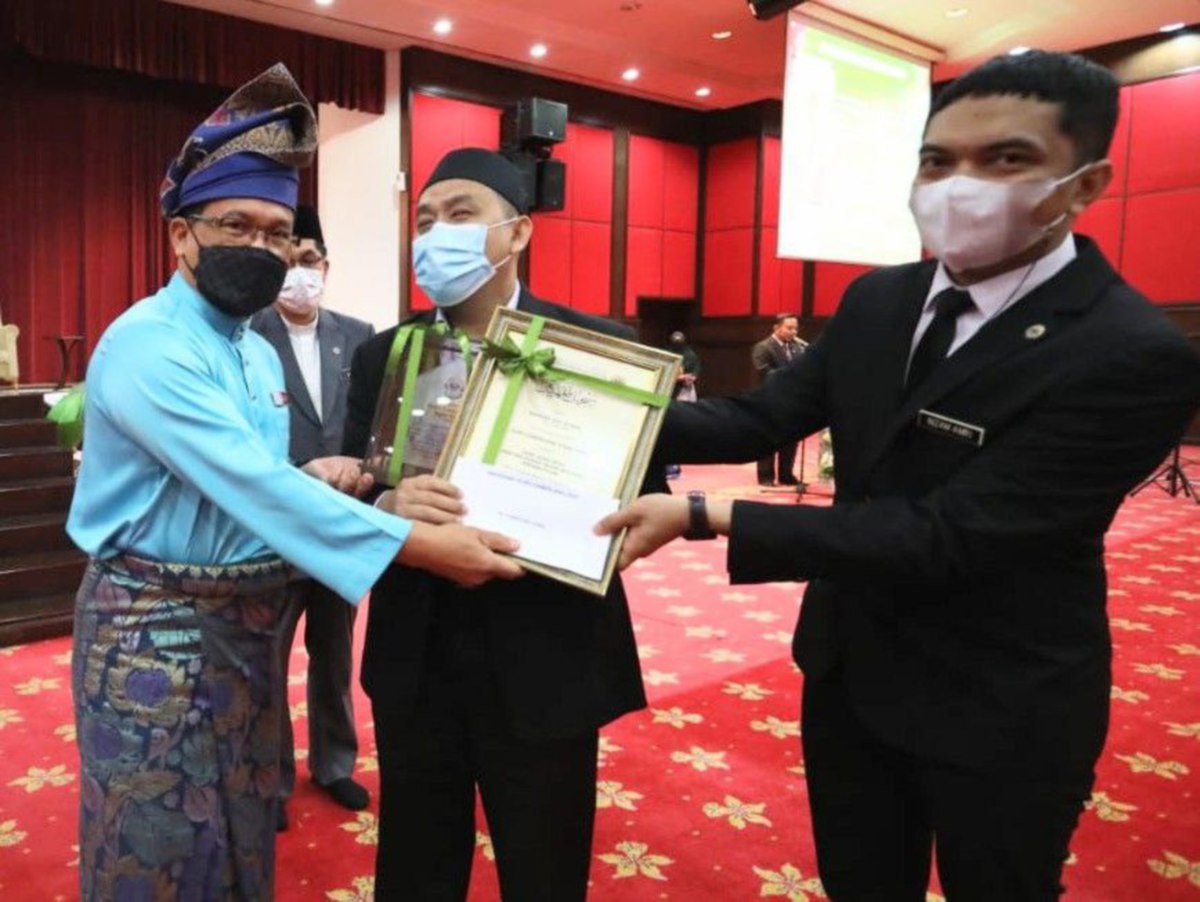 Sumairi (tengah) menerima Anugerah Guru Cemerlang Itqan KAFA yang disampaikan Mohd Ajib (kiri)  pada majlis Perhimpunan Bulanan Warga JAWI dan Sambutan Hari Guru yang  di Dewan Serbaguna Masjid Wilayah Persekutuan Kuala Lumpur semalam. FOTO ihsan Jawi