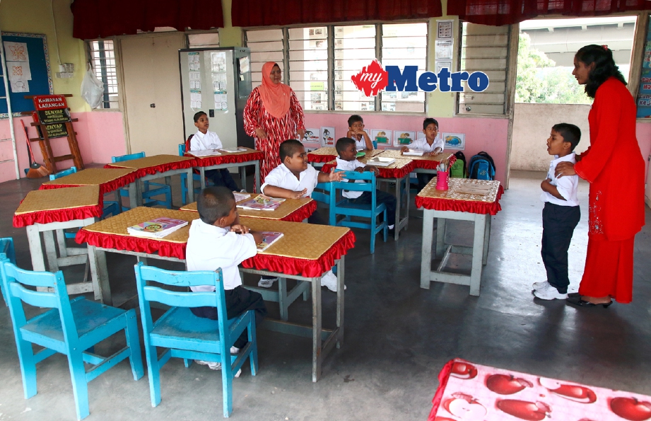 Guru Matematik R Jayapritha (kanan) ketika memulakan sesi pembelajaran hari pertama tujuh pelajar tahun satu SK Assumption, Pulau Pinang. - Foto AMIR IRSYAD OMAR