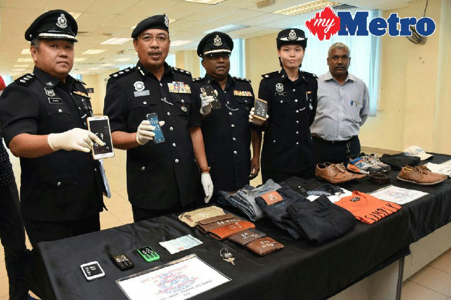Shafien (dua dari kiri) menunjukkan antara barangan yang dirampas daripada suspek samun. FOTO Mohd Asri Saifuddin Mamat