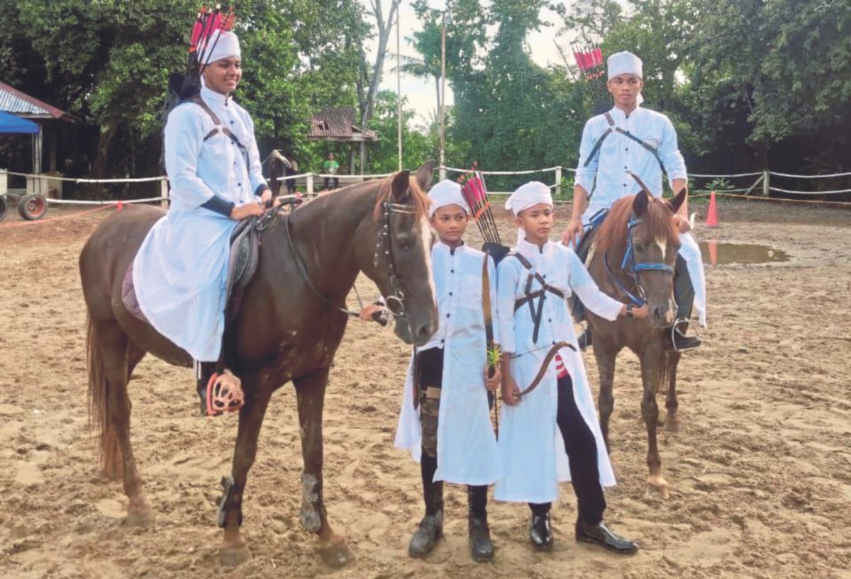 AKIF Zayan (berdiri kiri) bersama tiga lagi pelajar Maahad Tahfiz An-Nur yang aktif menunggang kuda sambil memanah. FOTO ihsan SHAHRILBANI MANSOR