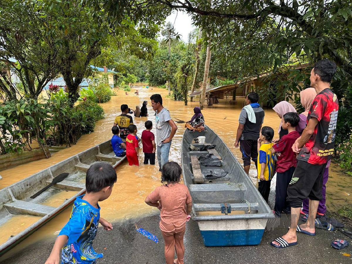 PENDUDUK menggunakan bot untuk merentasi Sungai Galas selepas Jambatan Sungai Kerak ditenggelami air sehingga penduduk terputus hubungan di Kampung Limau Kasturi, di sini, hari ini. FOTO Paya Linda Yahya