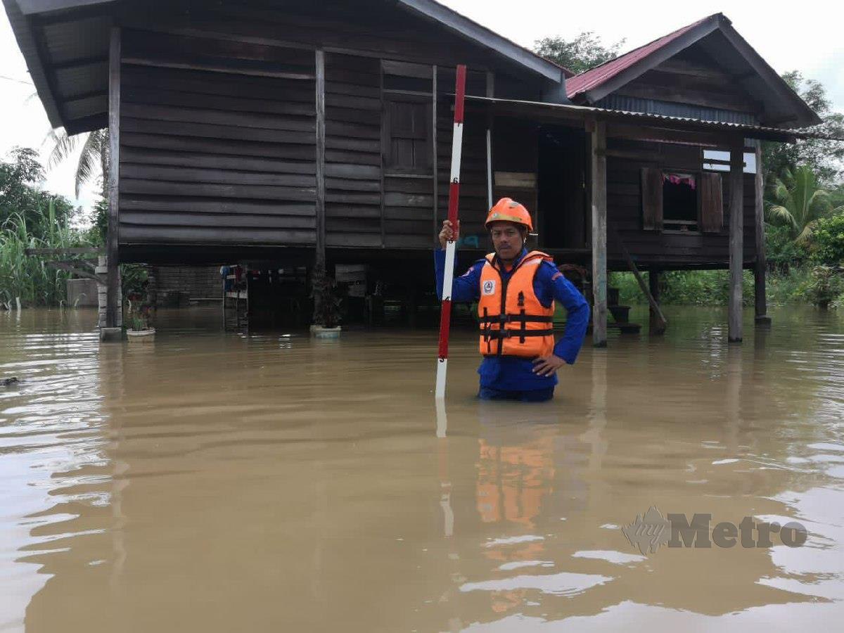 Anggota APM Pendang menyukat paras air dari Sungai Pendang yang melimpah susulan hujan lebat menyebabkan banjir di beberapa rumah penduduk. FOTO IHSAN APM