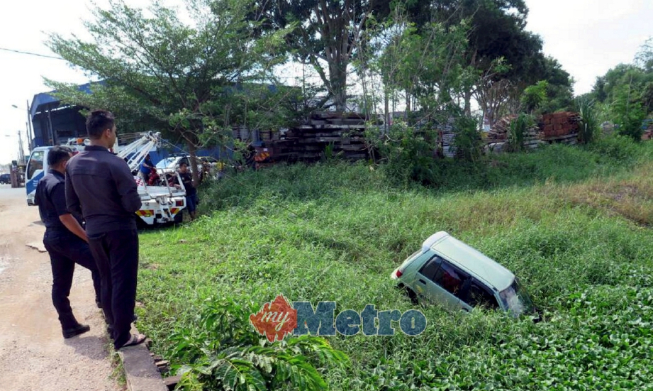 ANGGOTA polis melihat kereta Perodua Kancil ditarik pekerja trak tunda selepas terbabas dan terjunam ke dalam Sungai Malim, Melaka, hari ini. FOTO ihsan pembaca 
