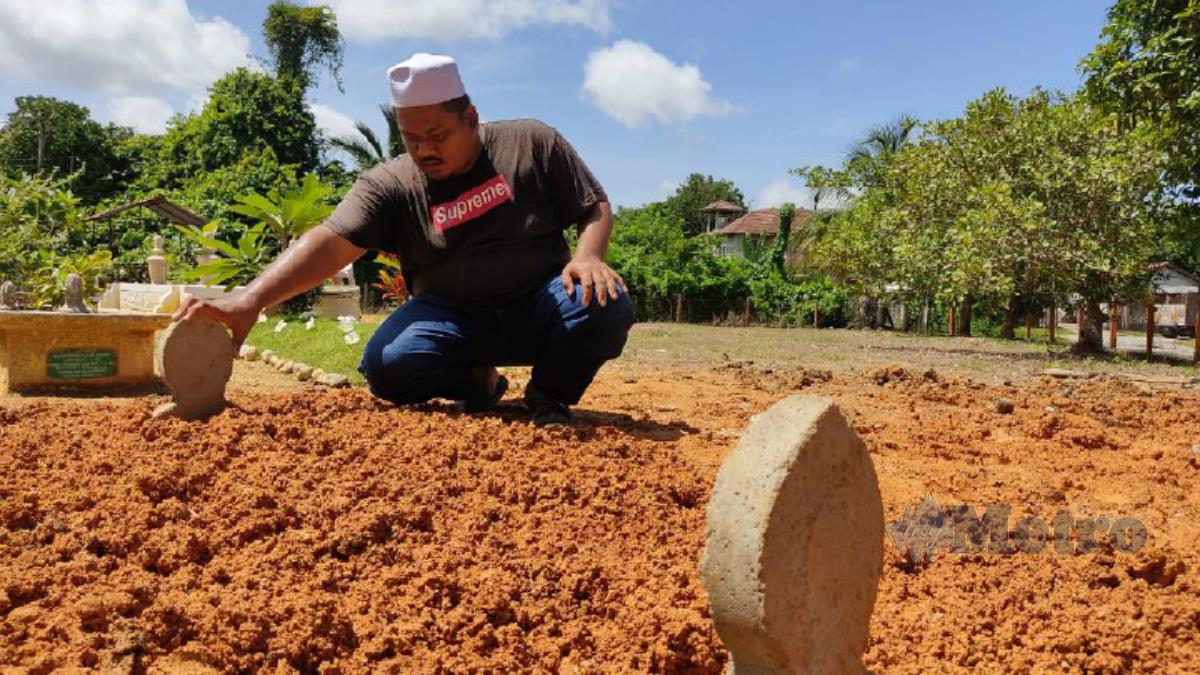 Mohd Zaid di kubur Allahyarham Siti Nur Surya di Kampung di Kampung Beladau Selat, Kuala Terengganu. Foto Zaid Salim 