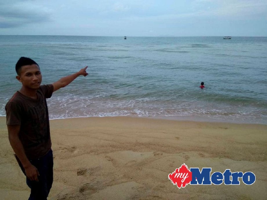 Rashid menunjukkan lokasi dua yu paus yang ditemuinya di Pantai Kampung Sura Hujung. FOTO Rosli Ilham