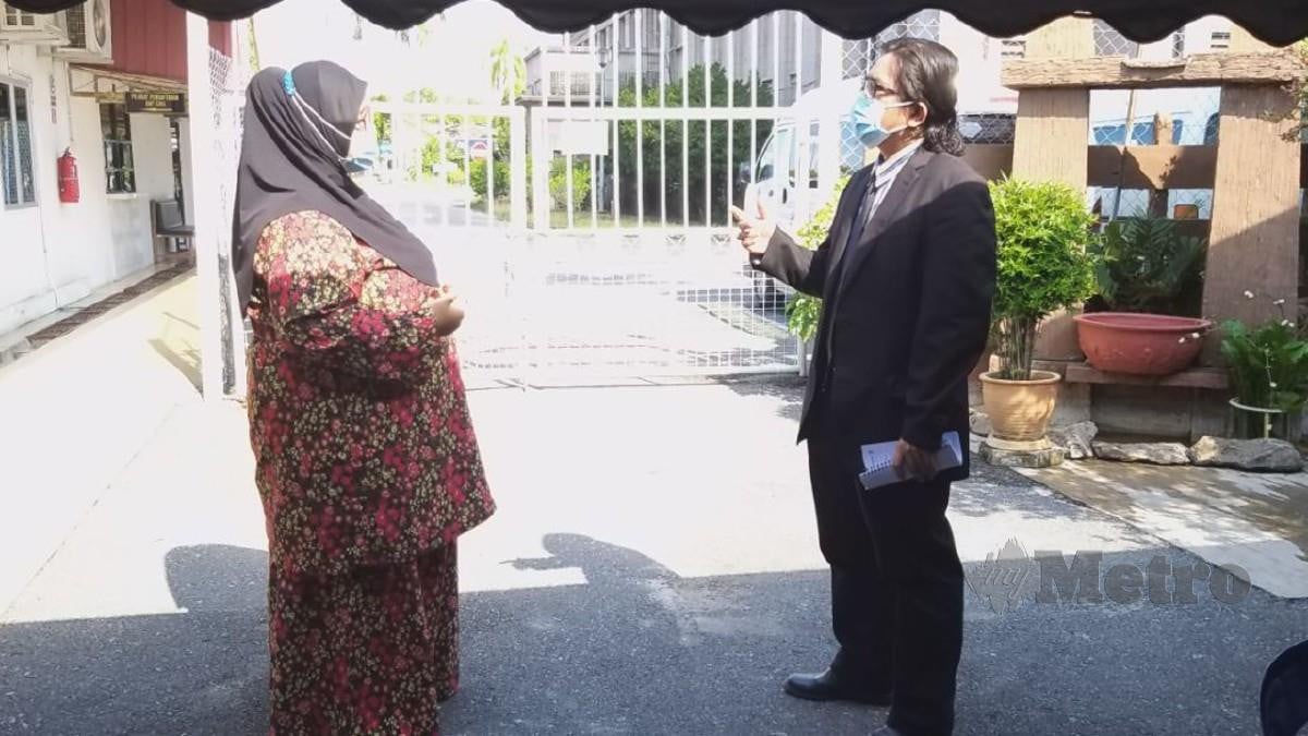 Norjannah berbincang dengan Zuhair di pekarangan Mahkamah Sesyen Kangar hari ini. Foto Aizat Sharif