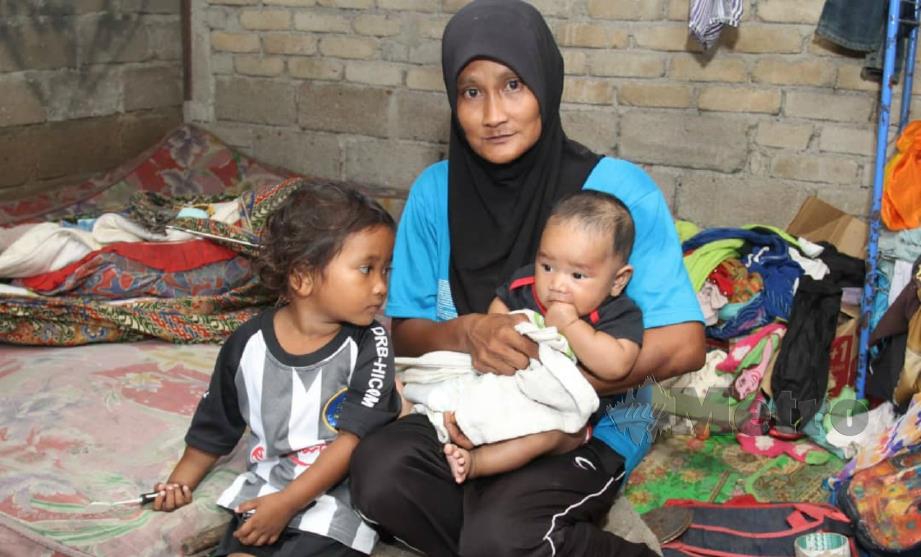 NORIZA bersama dua anaknya yang dibawa bersama ketika mencari besi buruk. FOTO Nik Abdullah Nik Omar. 