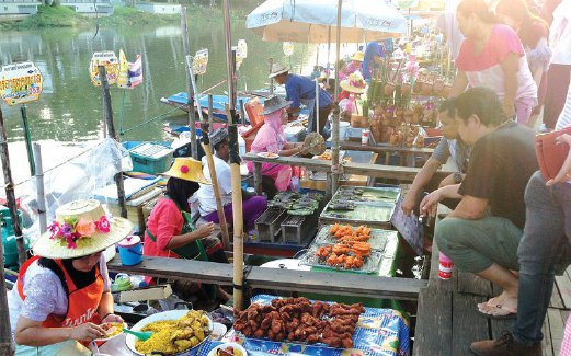 TERPEGUN melihat peniaga di pasar terapung di Hatyai, Thailand.