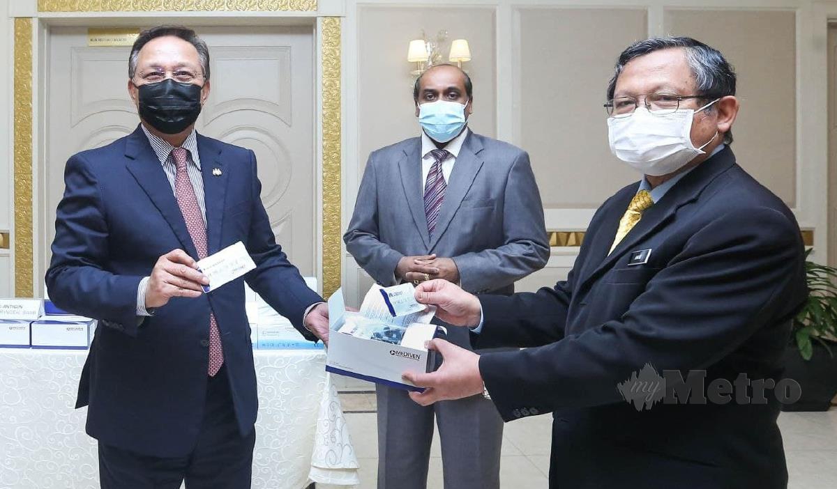 HASNI (tengah) menyerahkan kit ujian kepada Pengarah Kesihatan Negeri Johor, Datuk Dr Aman Rabu (kanan). FOTO Ihsan Pejabat Menteri Besar Johor.