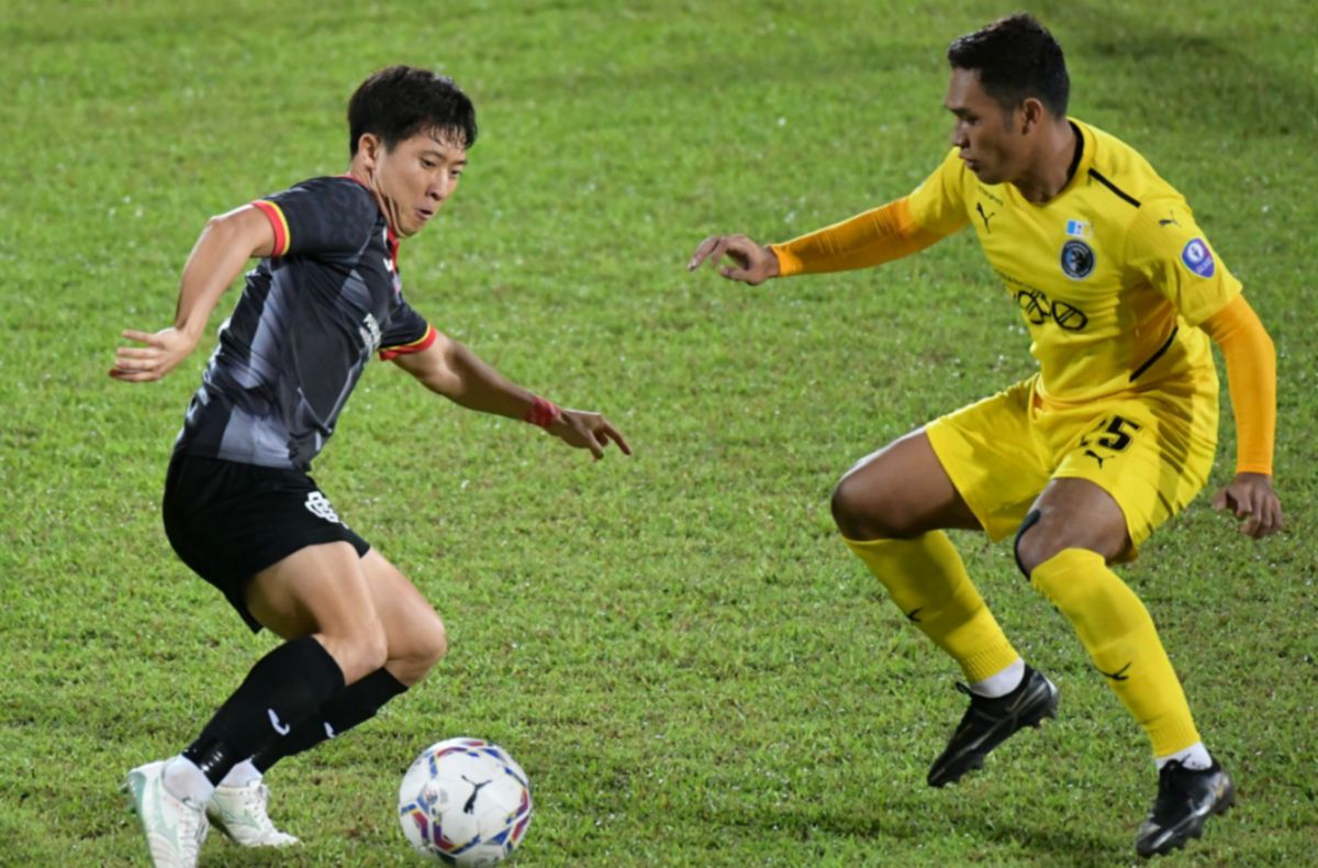 AKSI pemain Sarawak United, Lee Changhoon (kiri) cuba memperdayakan pemain Penang FC di Stadium Negeri minggu lalu. FOTO Bernama