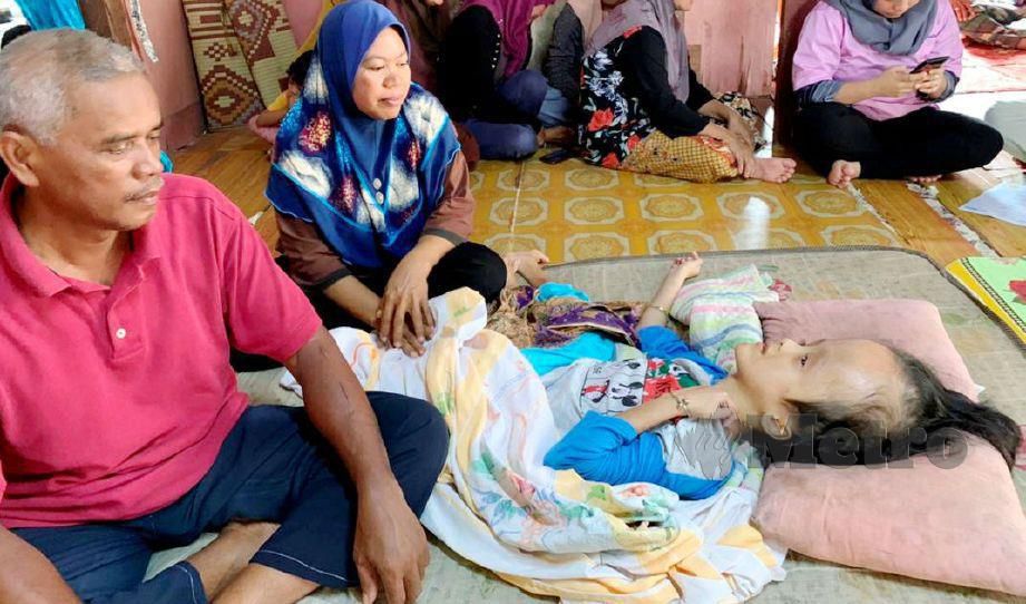 ZUBAIDAH (dua dari kiri) menjaga Siti Nurul Syafiqah yang menghidap hydrocephalus di Kampung Pangkal Kerdas, Tok Bok. FOTO Hazira Ahmad Zaidi