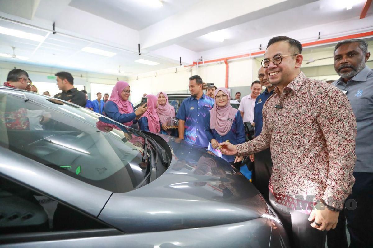 Steven Sim menyempurnakan majlis menandatangani papan tanda dan penyerahan kenderaan EV oleh Autotronics Center of Excellence Sdn Bhd kepada ADTEC Melaka.