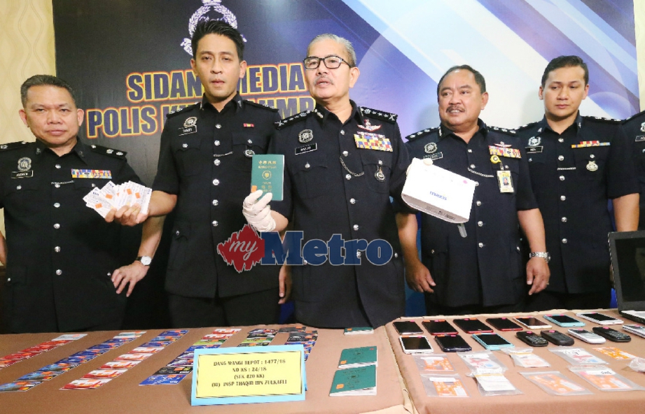 MAZLAN (tengah) bersama pegawainya menunjukkan barang rampasan hasil penahanan empat lelaki yang juga ahli sindiket Macau Scam pada sidang media di IPK Kuala Lumpur, hari ini. FOTO Owee Ah Chun.