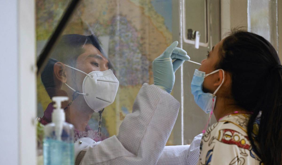 PETUGAS kesihatan melakukan ujian calitan Covid-19 terhadap penduduk Bon Kai, Bangkok. FOTO AFP
