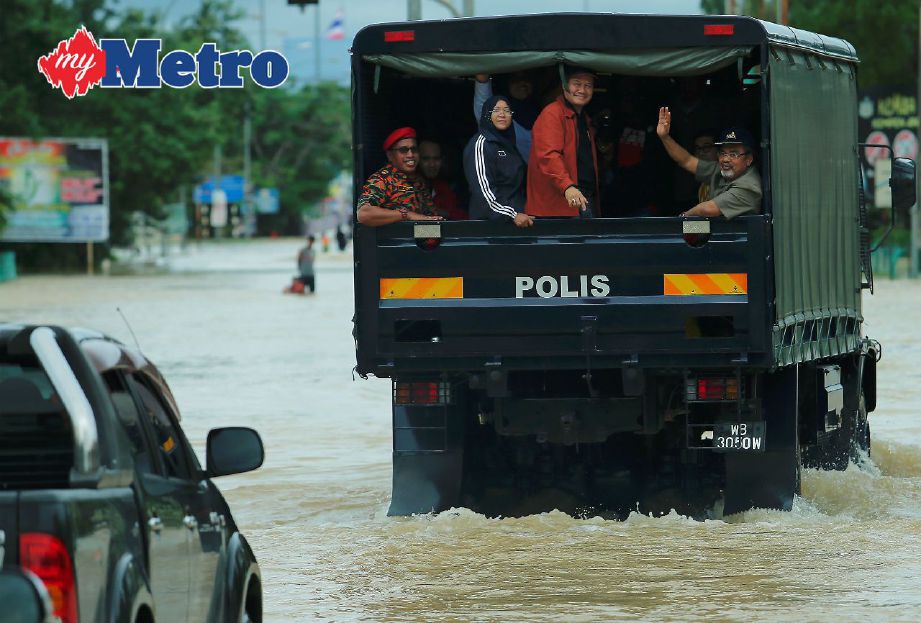 Tajuddin (kanan) meninjau kawasan banjir di sekitar pekan Rantau Panjang. FOTO Fathil Asri.