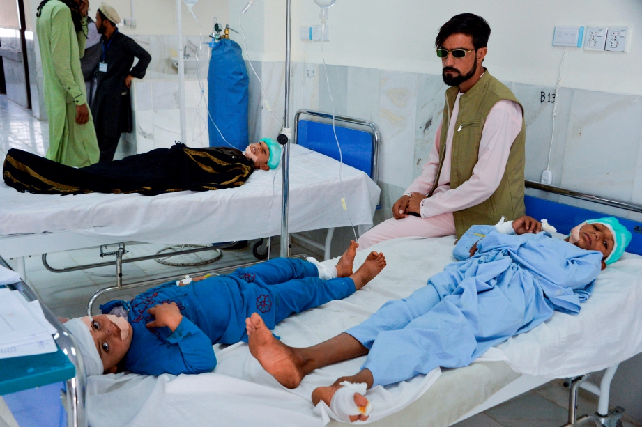 KANAK-KANAK yang cedera antara mangsa serangan bom trak menerima rawatan di hospital di Alishang, Laghman. FOTO: AFP