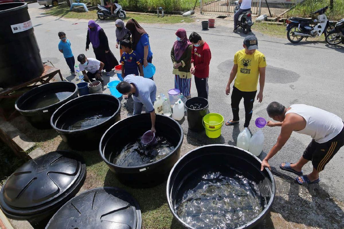 PENDUDUK TDTD mengambil air dari lori tangki susulan gangguan bekalan air. FOTO Ghazali Kori