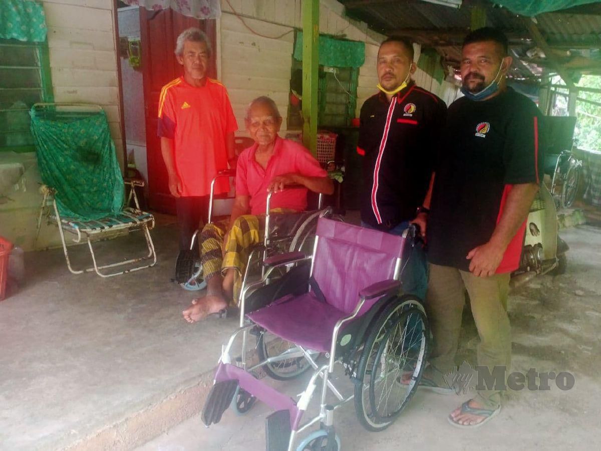 Tamin Sudin (duduk kerusi roda)  ketika ditemui di rumahnya di Felda Bukit Jalor, Tampin. FOTO MOHD KHIDIR ZAKARIA