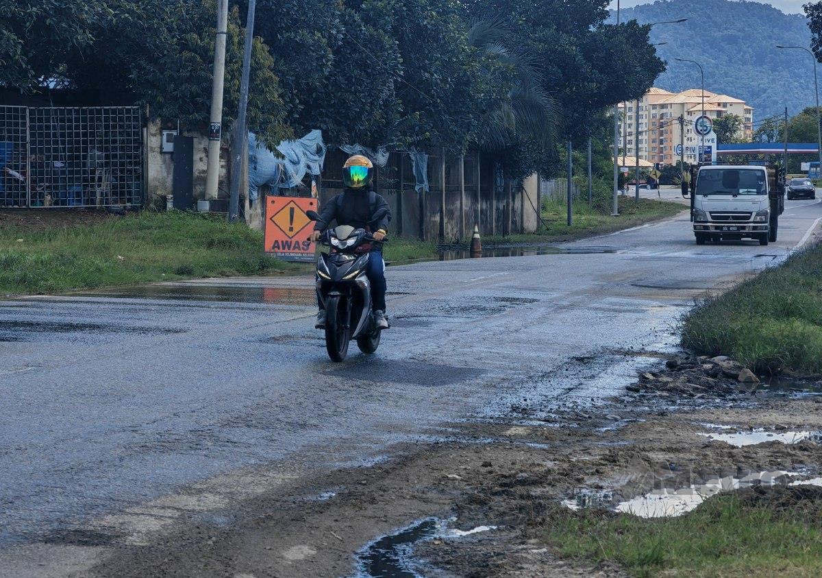 KENDERAAN melalui Jalan Mantin-Beranang yang mengalami kerosakan sehingga meragut nyawa kelmarin. FOTO Azrul Edham