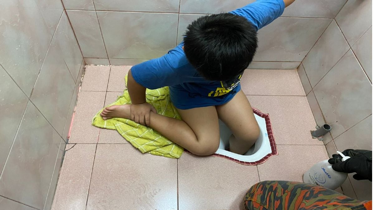 Anggota bomba membantu mengeluarkan kaki seorang kanak-kanak yang tersepit dalam mangkuk tandas di sebuah rumah di Taman Sri Rambai, Kuala Selangor. FOTO Ihsan JPBM.