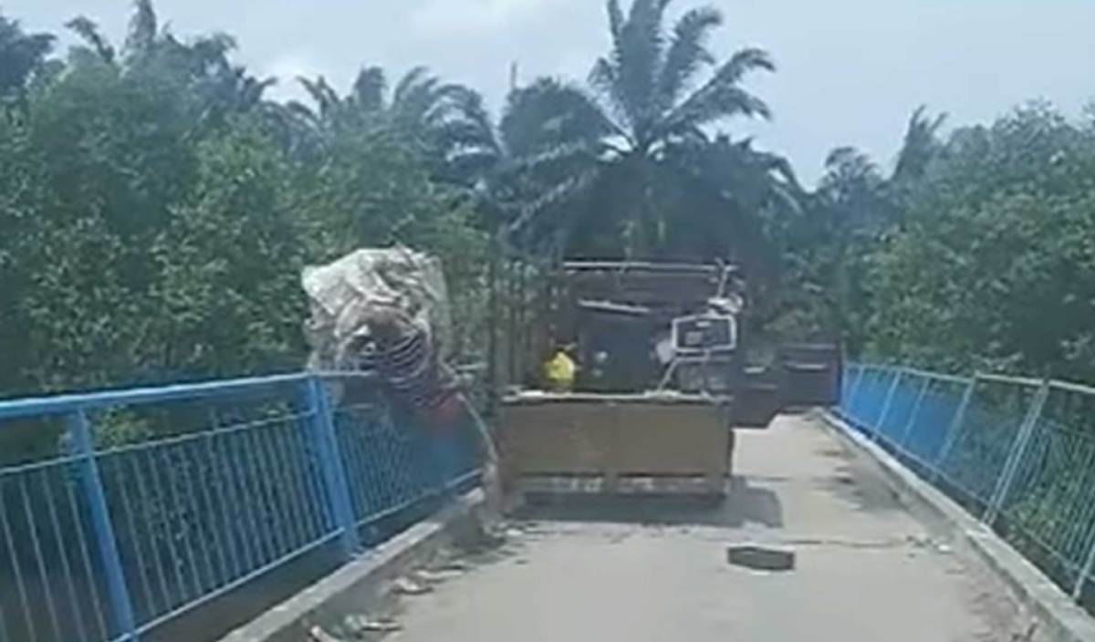 TANGKAP layar video berdurasi 36 saat memaparkan seorang pemandu lori memberhentikan lori dan membuang sampah dari atas jambatan Sungai Wak Rabun Batu 33, Pontian. FOTO TikTok mohdhairimohdhai7