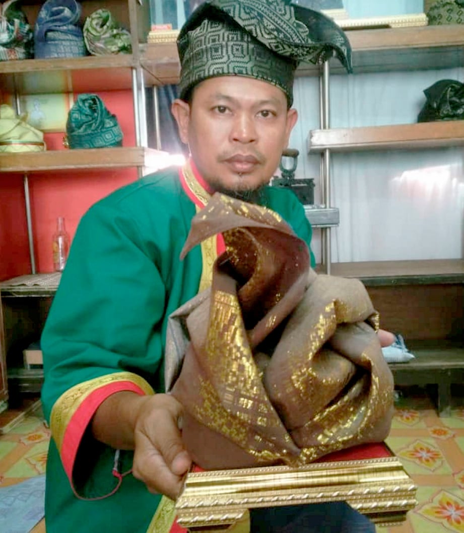 MOHD Yatim Mustaffa menunjukkan tengkolok yang dinamakan gagak di rimba yang pernah ditawarkan dengan harga RM2,200 tiga tahun lalu.FOTO NOORAZURA ABDUL RAHMAN