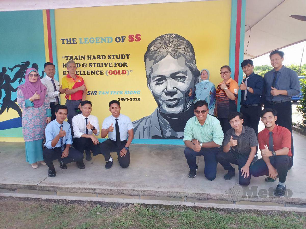 TAN TECK SIONG (tiga dari kiri) bersama guru dan pelajar bergambar dengan mural wajahnya di dinding gimanasium Sekolah Menengah Kebangsaan Sultan Sulaiman. FOTO AHMAD RABIUL ZULKIFLI