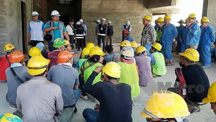 Pegawai Penguat Kuasa CIDB beri penerangan kepada pekerja tapak projek pembinaan ketika operasi bersepadu di Tawau, hari ini. Foto Abdul Rahemang Taiming