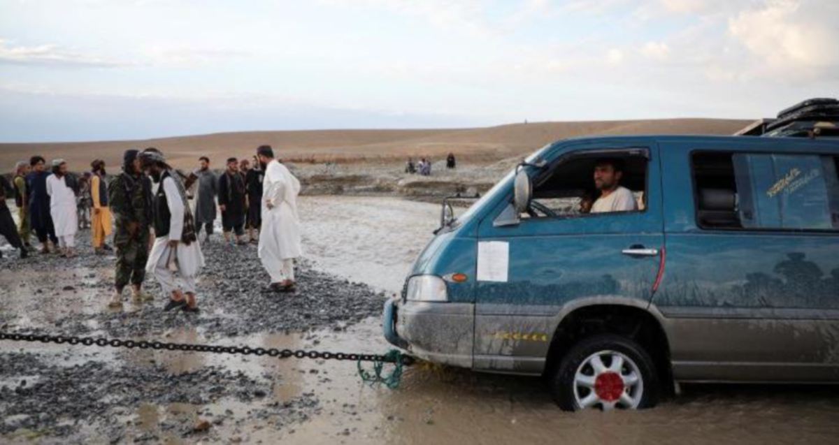 PENDUDUK membantu menarik kenderaan yang tersekat di kawasan banjir di Logar, Afghanistan. FOTO Reuters