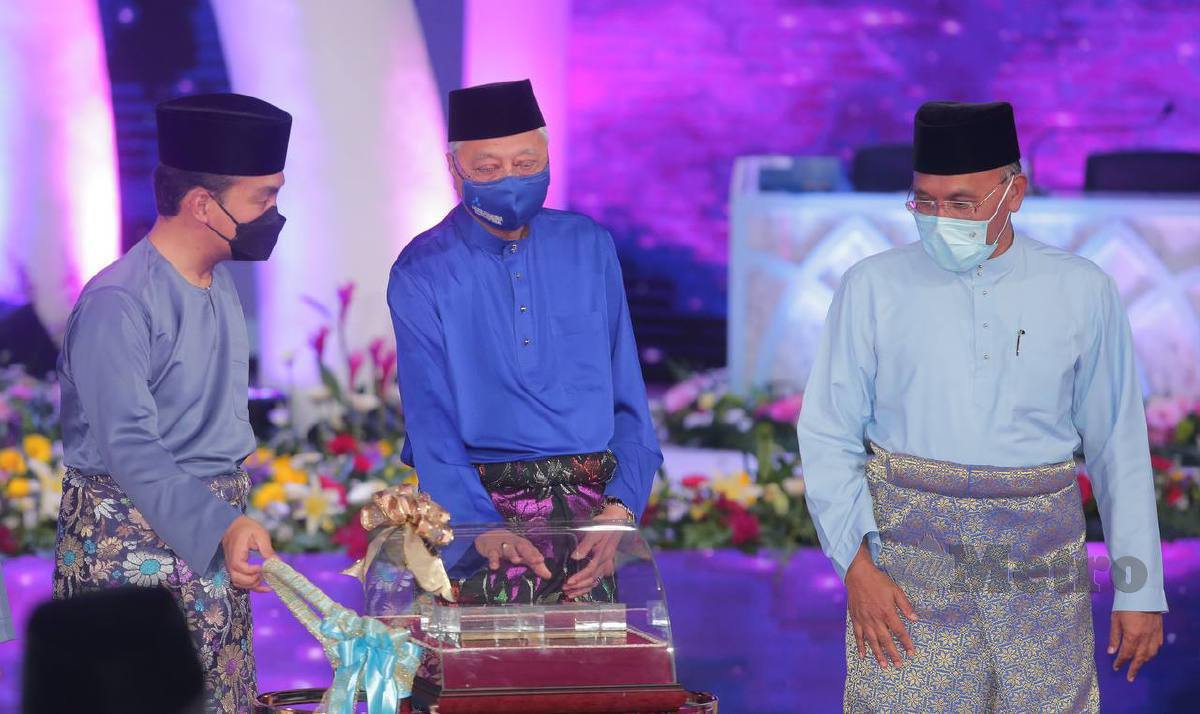ISMAIL Sabri menerima cenderamata daripada Datuk Onn Hafiz (kiri) sambil diperhatikan Idris pada Majlis Perasmian Pembukaan Majlis Tilawah dan Hafazan al-Quran Peringkat Kebangsaan 2022 di Dewan Pusat Islam Iskandar, Johor. FOTO Nur Aisyah Mazalan
