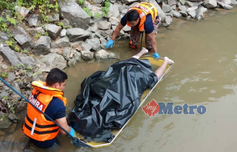 ANGGOTA bomba mengangkat mayat lelaki ditemui terapung di Sungai Perak berhampiran projek jambatan Sayong, Manong, Kuala Kangsar, hari ini. FOTO ihsan bomba.