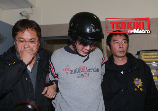 Polis hari ini mengiringi lelaki yang memenggal kepala budak perempuan di Taipei semalam. - Foto AFP