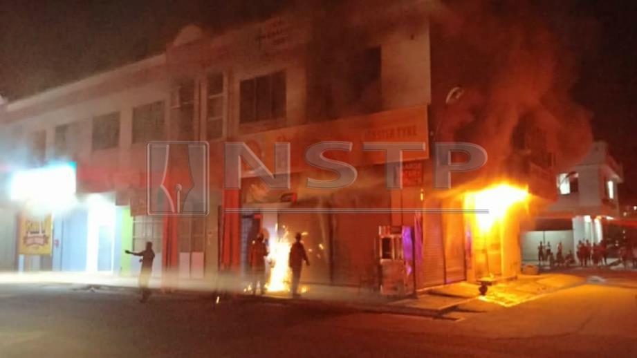 BANGUNAN dua tingkat yang menempatkan kedai tayar dan bengkel kereta terbakar. FOTO Ihsan Bomba