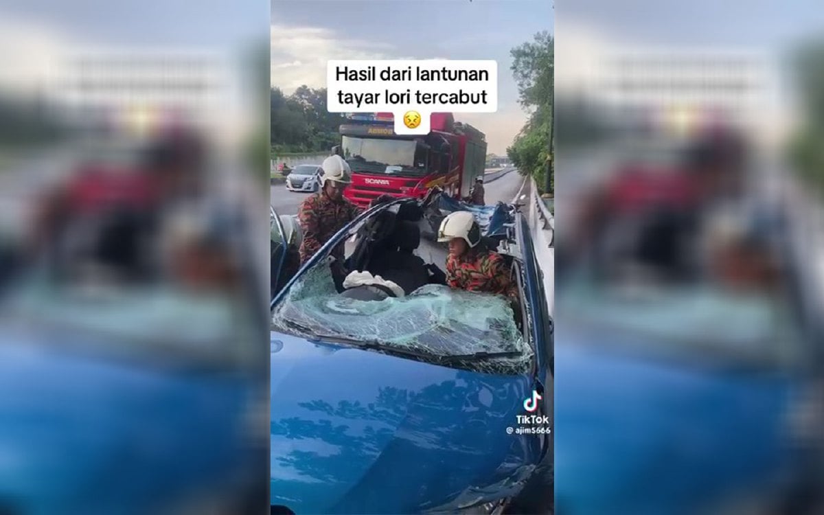 Anggota bomba memeriksa kereta yang remuk dihempap tayar lori tercabut di Jalan Tuanku Abdul Halim, Kuala Lumpur, kelmarin. FOTO tangkap layar video viral.
