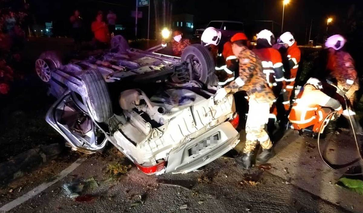 ANGGOTA bomba berusaha mengeluarkan dua mangsa yang tersepit di dalam kereta yang terbalik selepas terbabas di Jalan Batu Kitang, Kuching. FOTO Ihsan JBPM