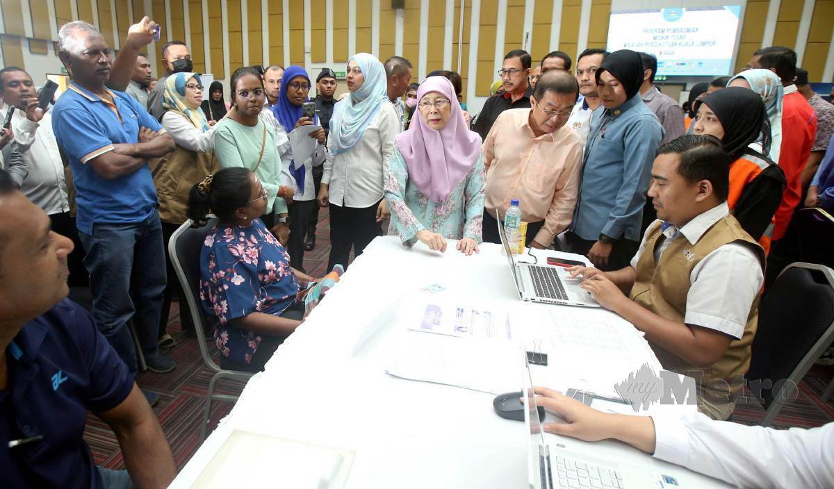 WAN Azizah (tengah) beramah mesra dengan penerima sumbangan ketika Program Pembasmian Miskin Tegar di Wilayah Persekutuan Kuala Lumpur bagi Parlimen Bandar Tun Razak dan Cheras di Institut Latihan DBKL, Cheras. FOTO Hairul Anuar Rahim