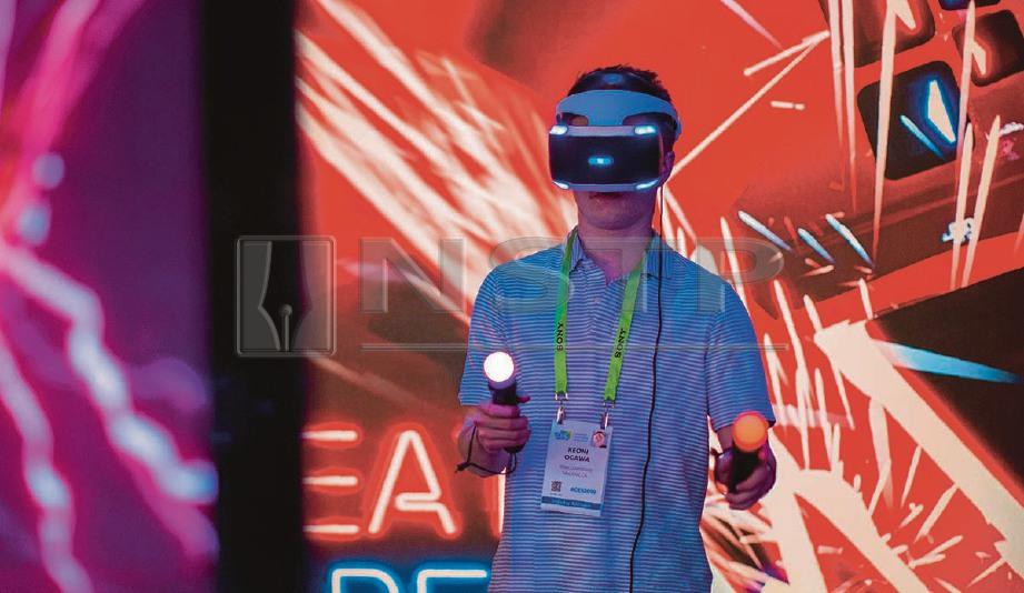  PENGUNJUNG CES mencuba permainan Beat Saber menggunakan Playstation VR. -Foto AFP