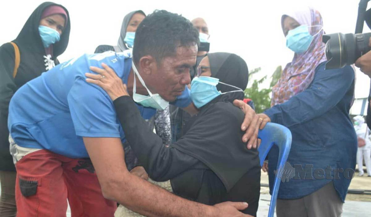 TUAN Azhar (dua kiri) disambut keluarga selepas dibawa pulang oleh Agensi Penguatkuasaan Maritim Malaysia (APMM) di jeti APMM Tok Bali, Pasir Puteh. FOTO Nor Amalina Alias