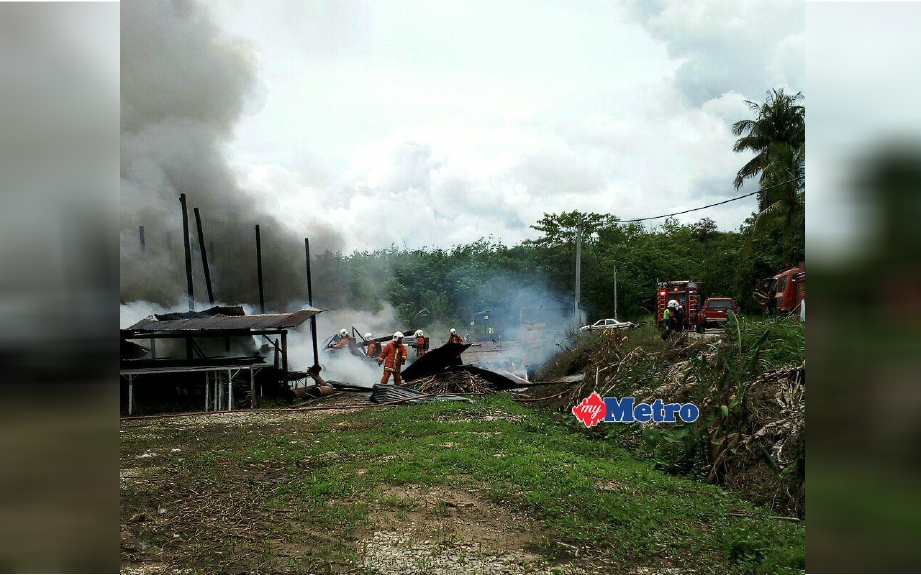 Anggota bomba berusaha memadam kebakaran yang memusnahkan gudang tembakau dan getah beku di Jalan Lata Bayu tengah hari tadi. FOTO ihsan bomba