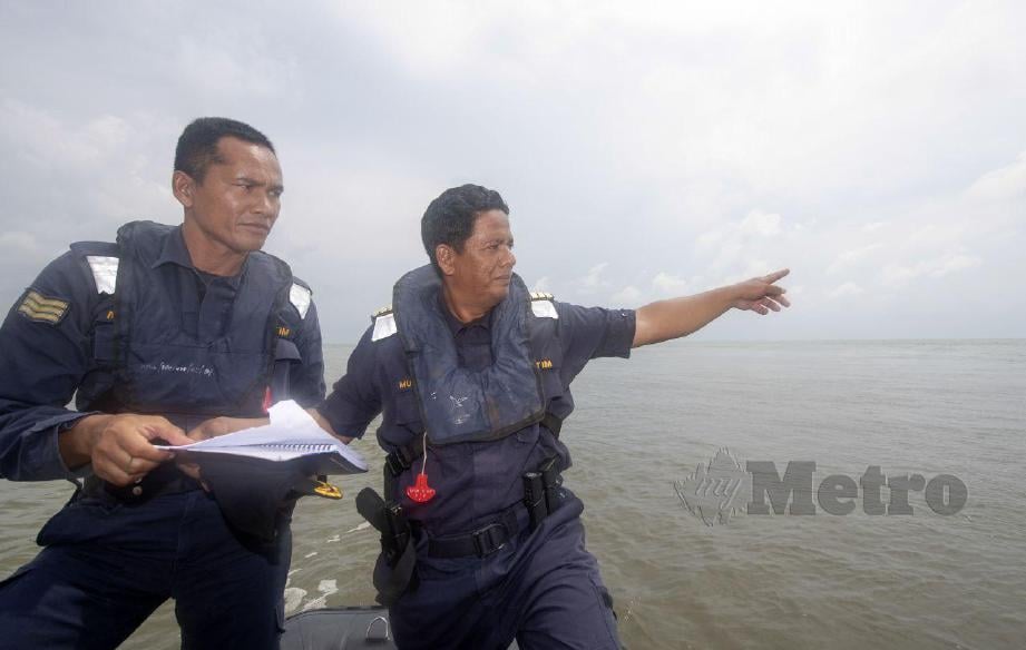 MUHD NUR Syam bersama pegawainya berbincang di atas bot kilat untuk memperluaskan kawasan pencarian dua lagi mangsa bot terbalik yang masih hilang di Perairan Kuala Kemasin. FOTO NIK ABDULLAH NIK OMAR