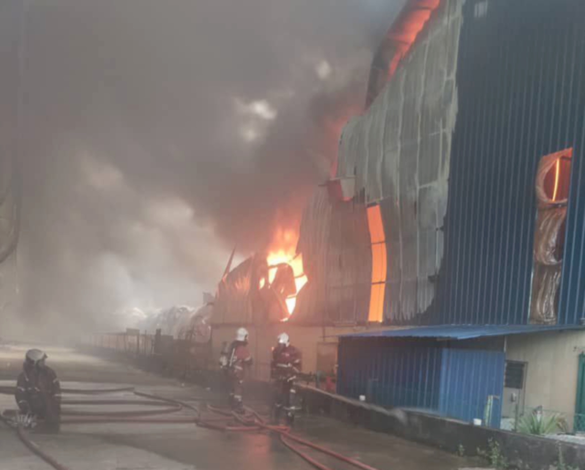 Anggota bomba memadam kebakaran lima buah kilang kelas B  di Jalan Industri 5, Kampung Baru Sungai Buloh, di sini, hari ini. FOTO IHSAN BOMBA