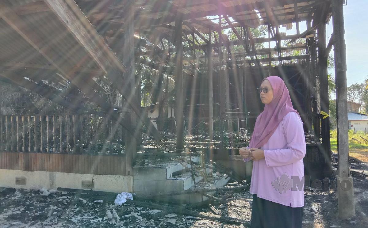 Maziani Sudin, 29, melihat rumah sewanya di Kampung Paya Besar, yang hangus terbakar. FOTO NAZDY HARUN