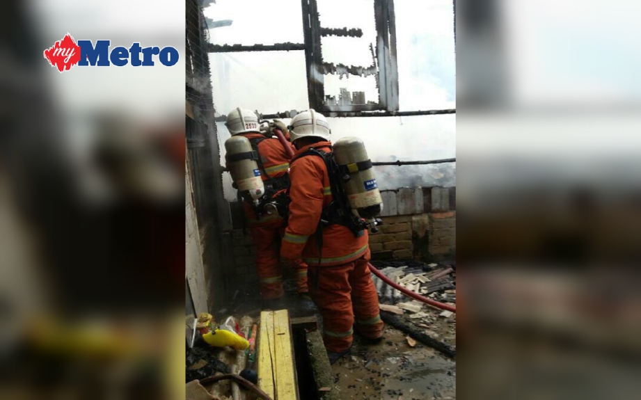 Anggota bomba berusaha memadamkan kebakaran sebuah rumah di Kampung Pulai Hilir, Kubang Kerian, pagi tadi. FOTO Ihsan Bomba