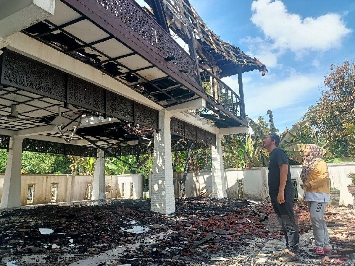 Norsharinawati dan suaminya, Mohd Shukri Muhammad melihat keadaan rumah mereka yang musnah 80 peratus dalam kebakaran di Kampung Lubok Jambu, di sini. FOTO SITI ROHANA IDRIS