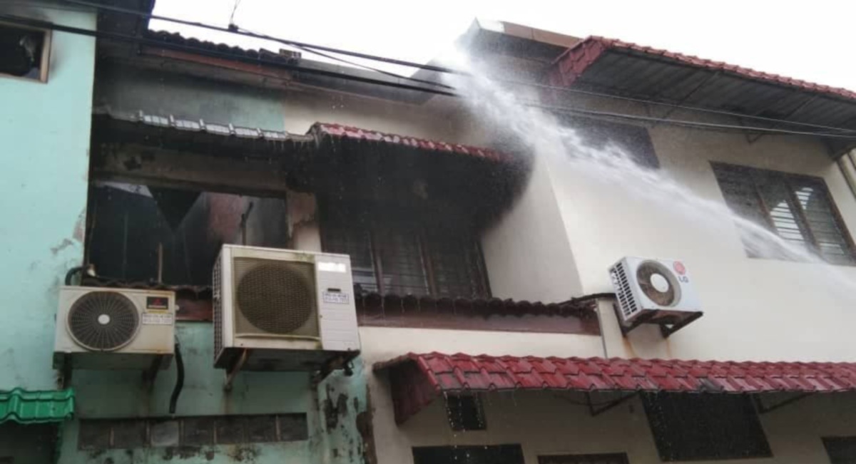 ANGGOTA bomba menjalankan operasi pemadaman rumah teres dua tingkat di Taman Permas Jaya yang terbakar 50 peratus. FOTO IHSAN BOMBA