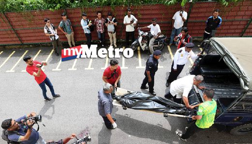Anggota polis mengangkat mayat Baskaran. FOTO Mikail Ong